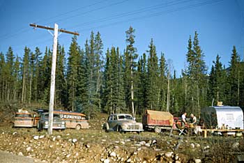 Temporary camp set up along the highway while drivers wait days for crews to repair the Rancheria River Bridge. 1948.