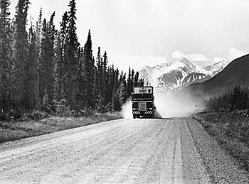 A transport truck on a dusty Alaska Highway.