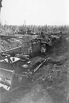 Bulldozers excavating a ditch. ca. 1942.
